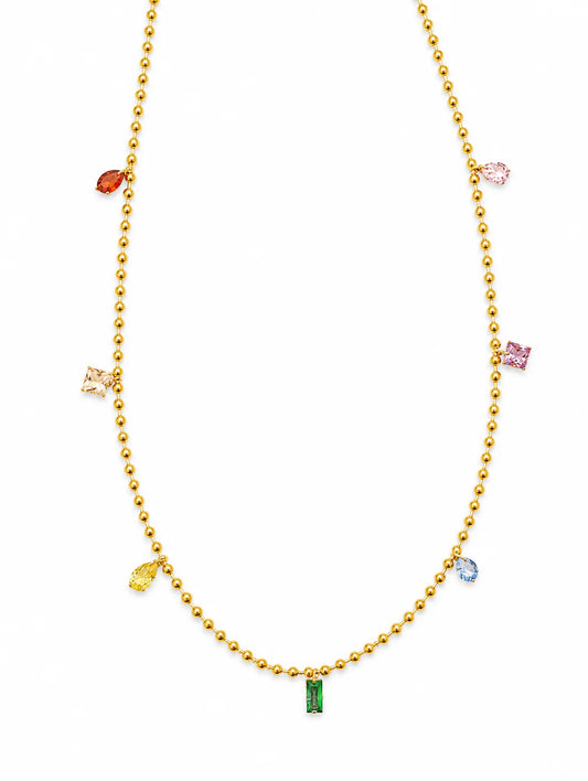 A gold beaded necklace featuring small, colorful gemstone charms in red, pink, yellow, blue, and green, displayed on a clean white background.