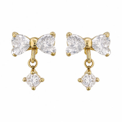 A pair of gold bow-shaped drop earrings with clear gemstones, shown on a plain white background.